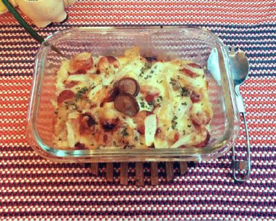 香肠芝士焗饭 1.把煮好的米饭加鸡蛋和佐料炒好装入可放进烤箱的容器中 2.如图 先均匀铺上香肠和烤肠，再铺满芝士条或芝士碎，加入少许凉薯（使口感丰富） 3.入烤箱 220度 15至20分钟左右，出烤箱后撒上少许欧芹叶就…