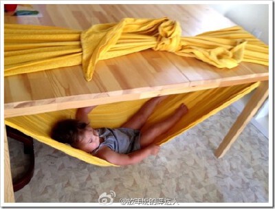 #家用吊床DIY#一位名叫Emily 的妈妈想给心爱的小女儿做个小吊床，但是没有地方和道具，也找不到“权威”的制作方法，于是她发挥了自己 的聪明才智，利用家里的餐桌做了这么个小吊床，小女儿躺在上面还有几分在山洞里…