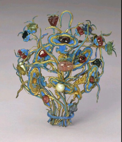 清代 银镀金嵌珠宝钿花 故宫博物院藏品
银镀金嵌珠宝钿花，清，长14.5厘米，宽11.8厘米。
钿花银镀金地上雕如意头形灵芝等仙草，仙草纹样用金属线勾勒，曲折四蔓，细腻精工。
线条间凹陷处点翠，装饰精美。錾刻…