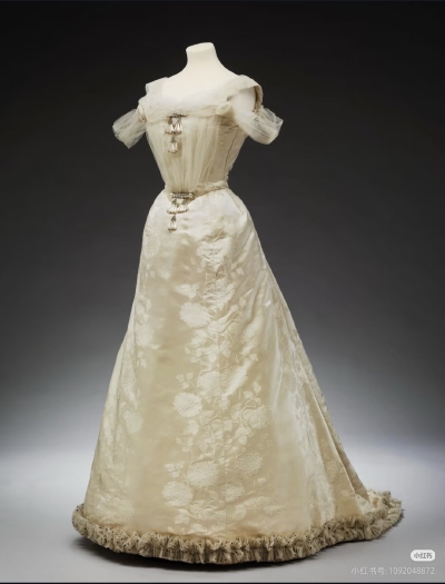 英国王后亚历山德拉的象牙白礼服
这件约制作于1895—1904年的晚礼服出自巴黎高级时装屋 Maison Laferrière，曾为丹麦亚历山德拉公主（后来的英国王后亚历山德拉）所有。礼服采用提花缎面，搭配仿珍珠、水钻、亮片与…
