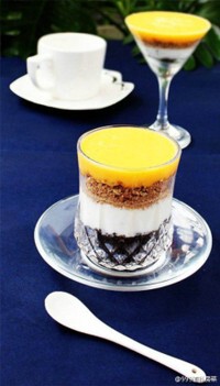 【芒果乳酪杯】1.将饼干装进食品袋中,用擀面杖碾碎;2.将洗净的芒果去核,放入搅拌机中搅拌成果泥;3.在玻璃杯中放入巧克力饼干碎;4.倒入适量酸奶;5.再放入适量全麦饼干碎;6.倒入适量芒果泥~