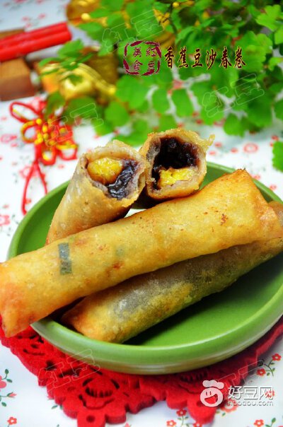 【香蕉豆沙春卷】做法：1）面粉加入适量的清水调成面糊备用，香蕉去皮切粗条。2）取一些豆沙馅放在春卷皮一侧，上面在摆放上一根香蕉条。3）卷起封口处均匀涂抹面糊，包成春卷生坯，依次全部包好。4）锅中油烧制5成…