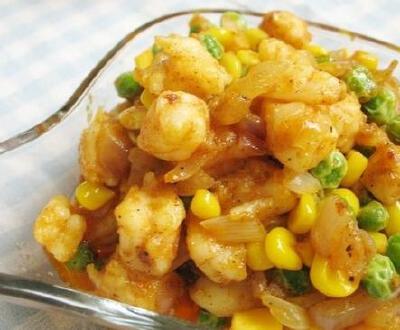 【咖喱什锦虾仁】热油锅，放入洋葱碎，小火翻炒至出现洋葱香味；咖喱块融化后，翻炒洋葱碎，使其入味儿；倒入虾仁段，转中火，翻炒，炒至虾仁变红并炒出红色虾油；倒入玉米粒和豌豆，翻炒；加入盐和黑胡椒碎，翻炒均…