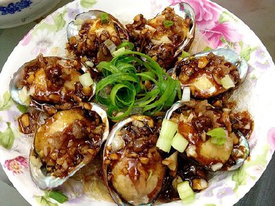 粉丝蒜茸蒸鲍鱼 龙口粉丝  一捆 鲍鱼  7个 蚝油  适量 酱油  适量 蒜头  少许 虾仁菜圃（超市瓶装那种）  少许 食用油  适量 1.取一个小碗粉丝泡软，蒜头剁碎，葱用手撕细丝， 2.盘底铺好泡好的粉丝剪成2半，上面一…