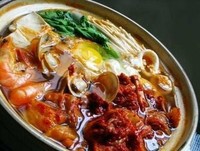 【韩式泡菜豆腐锅】1.鱿鱼、豆腐、泡菜、青椒切块，大葱切碎，大蒜、胡萝卜切片。 2.炒锅内放油，六成热时放入蒜片爆香，改中火放入韩式辣酱。 3.炒出红油后，放入鱿鱼翻炒，再加入豆腐、泡菜，炒匀后加水。 4.待水…
