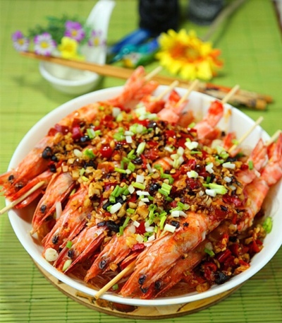 （蒜香串蒸竹节虾）做法：竹节虾清洗去肠沥干.用黄酒、胡椒粉腌制5分钟.为了防止蒸后变形.可用竹签一个个串好.可以保证在蒸的过程中不会弯曲.龙口粉丝在温水中浸泡10分钟.清洗后捞起.沥干水分.垫在盘底.淋少许鱼露.…