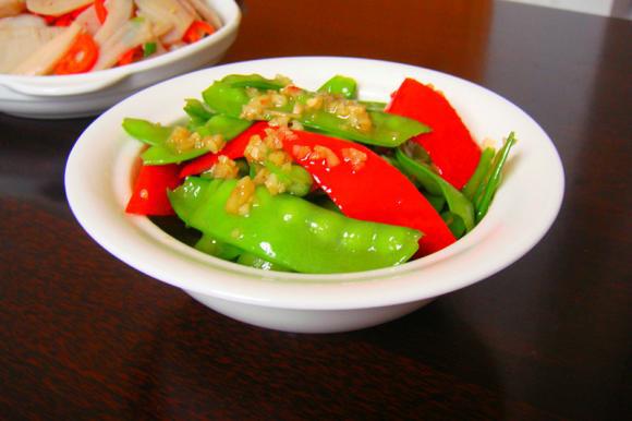 -【蒜香荷兰豆】- 【食材】： 荷兰豆400克、 红椒1个、 蒜、植物油 、盐、鸡精 【做法】： 1、荷兰豆两侧去筋洗净 2、红椒1个斜切成片 3、大蒜去皮切末 4、荷兰豆入沸水中焯一下，约20秒 5、捞出后放入装有冷水的盆里浸泡 6、凉透后捞出沥干，备用 7、锅中倒油，待油烧到7成热时放蒜末炒香 8、再放入荷兰豆煸炒1分钟 9、然后加入红椒片翻炒半分钟 10、最后加适量盐与味精炒匀，即可关火