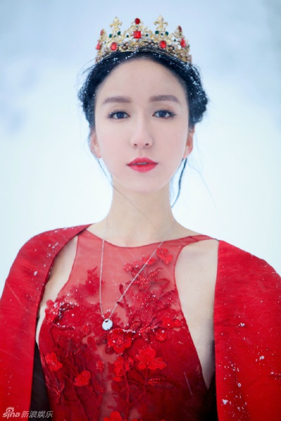 娄艺潇 曝光一组红衣圣诞大片——照片中娄艺潇长发盘起，身穿一袭红色镂空花朵长裙，置身于一片洁白的冰雪世界里，宛若仙子